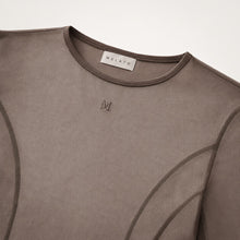 Close-up of the Melato Body Language Cocoa Mesh Bodysuit showing sheer cocoa mesh, contour seamwork, crew neckline, and tonal Melato label.