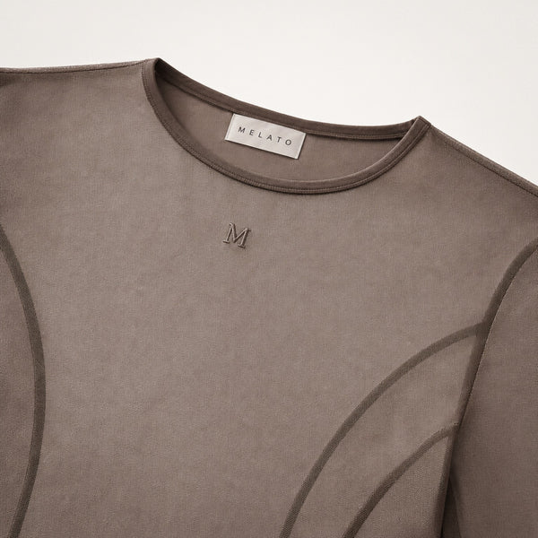 Close-up of the Melato Body Language Cocoa Mesh Bodysuit showing sheer cocoa mesh, contour seamwork, crew neckline, and tonal Melato label.