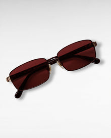 Tinted Testimony sunglasses detail view showing red lenses and maroon metal frame